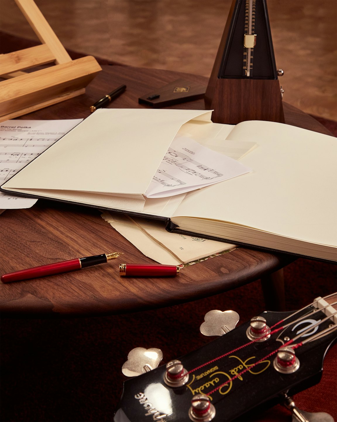 Strumenti musicali e spartiti disposti su una scrivania di legno.